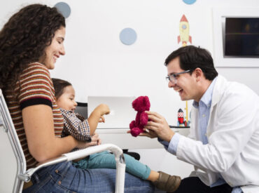 side-view-doctor-playing-with-baby-boy